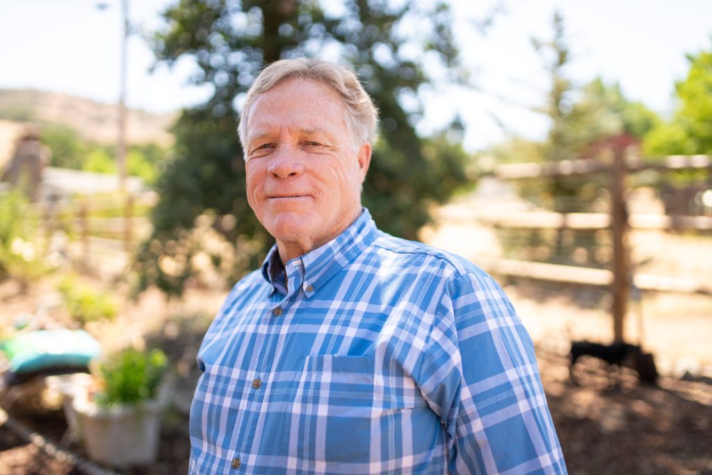 Jeff Thorsnes, a smiling older man in a blue plaid shirt, who earned his high school diploma at the age of 65.