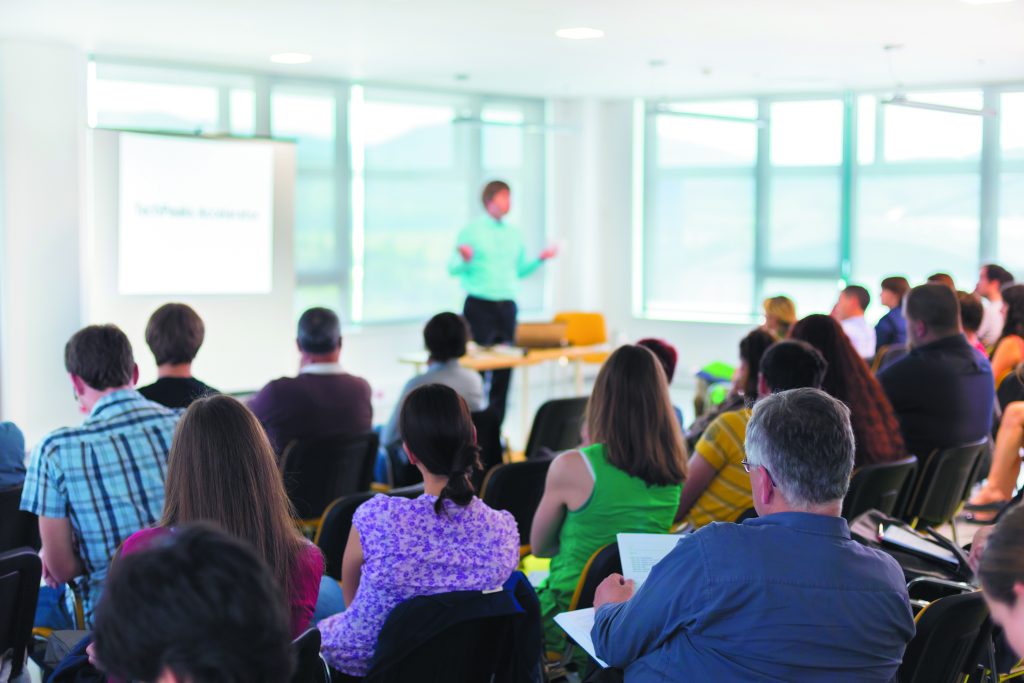 A teacher instructs a class of Adult Education students.