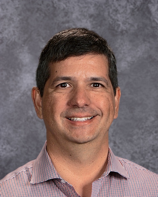 A headshot of Robert Gonzales, a smiling middle-aged man in a collared shirt.