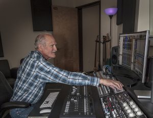 Marvin Stites, a retired man in a plaid shirt, works with recording equipment.