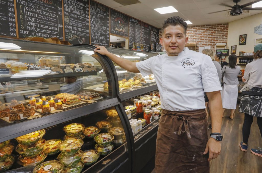 Jose Ernesto Quijada Hernandez stands at the display case of the popular French Oven Bakery and Cafe in the Scripps Ranch area of San Diego where he works in the kitchen cooking the sweet creations on display.