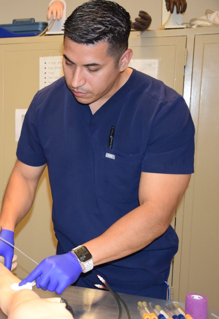 Manuel Martinez doing phlebotomy work in a lab