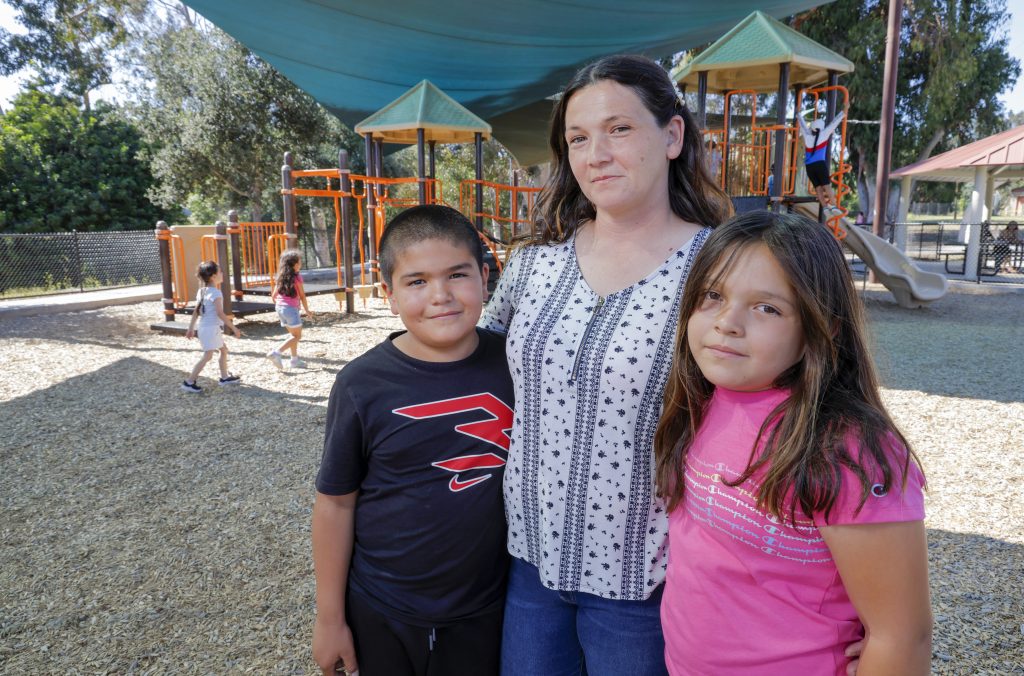 Portrait of Vista Adult School graduate Breanna Varela Perez with two of her four kids, Angel and Katelynn, at Fallbrook Community Park.