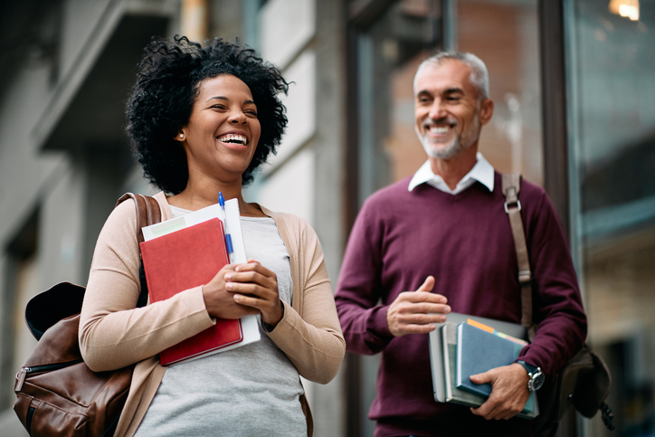 Happy adult students laughing together