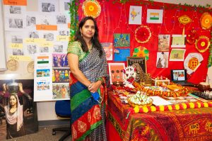 Photo of Vandana Sinha in a classroom filled with items from and representing India.