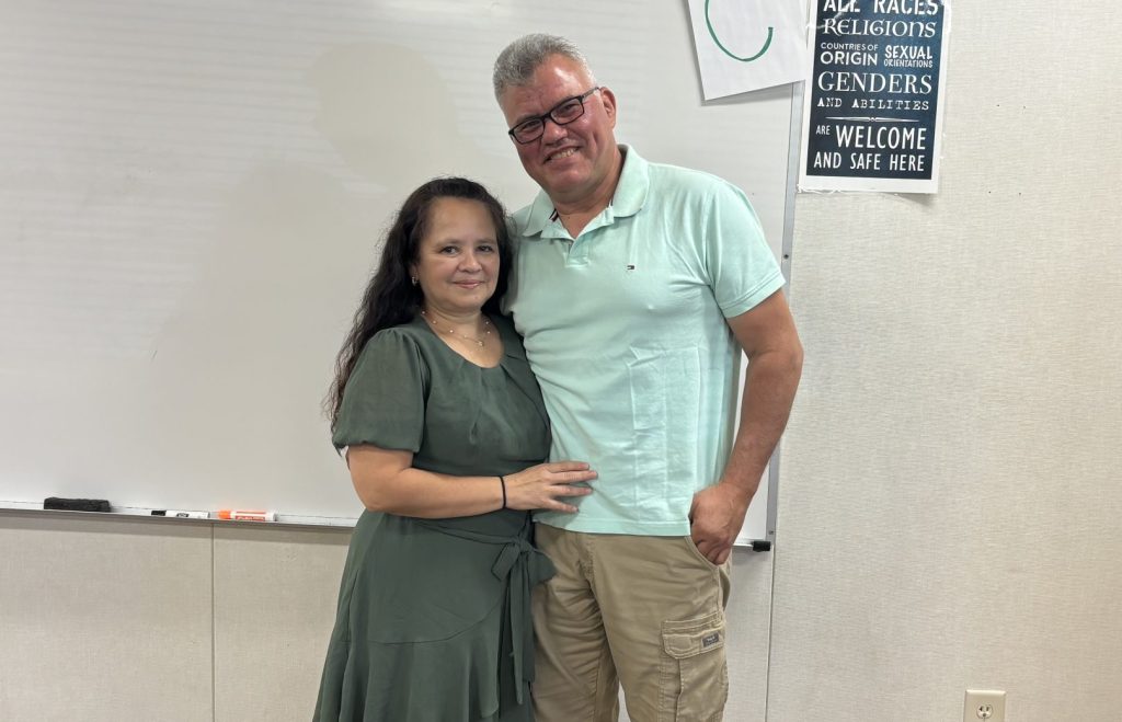 Gustavo Zielke and his wife, Rode standing together in a classroom