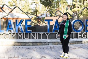 Lina Caro Flores standing in front of the Lake Tahoe Community College sign