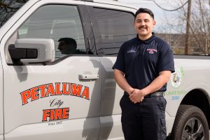 Man standing in front of a work truck, smiling.