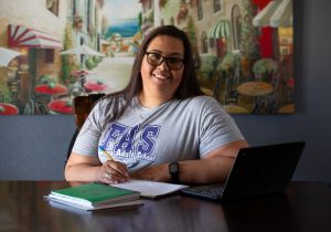 Woman smiling while sitting at desk in home office.