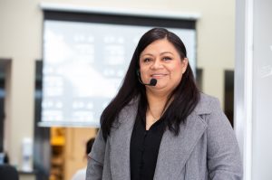 Mariela Trujillo, of San Bernardino, wearing a grey blazer and black shirt and an over the ear microphone, working as a translator during a meeting at the Warehouse Worker Resource Center in Ontario.