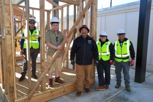 Daniel Toscano and students in work gear standing in front of a construction project