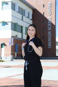 Marie Bell in scrubs smiling for the camera