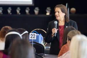 Mary Sandoval speaking into a microphone in front of a crowd