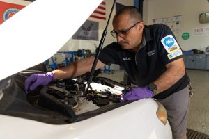 Raymond Zarate working on a car engine