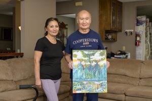 Ernesto Fiel holds a painting with his sister