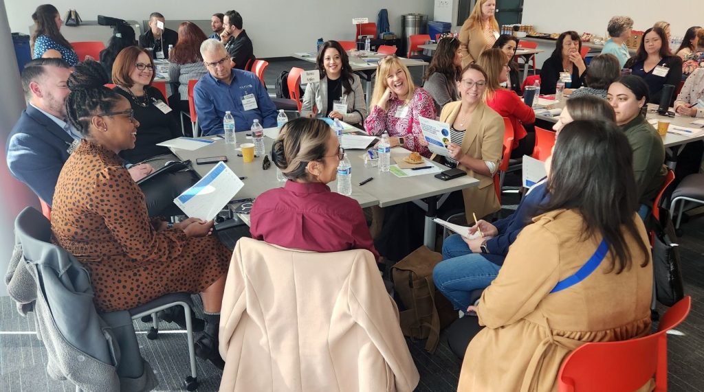 A group of people sitting around table talking.