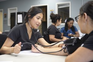 Iveth Gonzalez, right, practices taking blood pressure readings during her medical assistant class at Lompoc Adult School and Career Center (LASCC). As the first in her family to go to college, Gonzalez was overwhelmed the first time she attended college classes. When she found LASCC’s medical assistant certification program (which was free with her scholarship), she was able to start her career in the medical field. She currently works days as a substitute teacher and in the evenings attends classes online (with weekly in-person class for hands-on training). Lompoc has been such a positive experience, she’s reconsidering returning to college and is considering a career as a LVN.